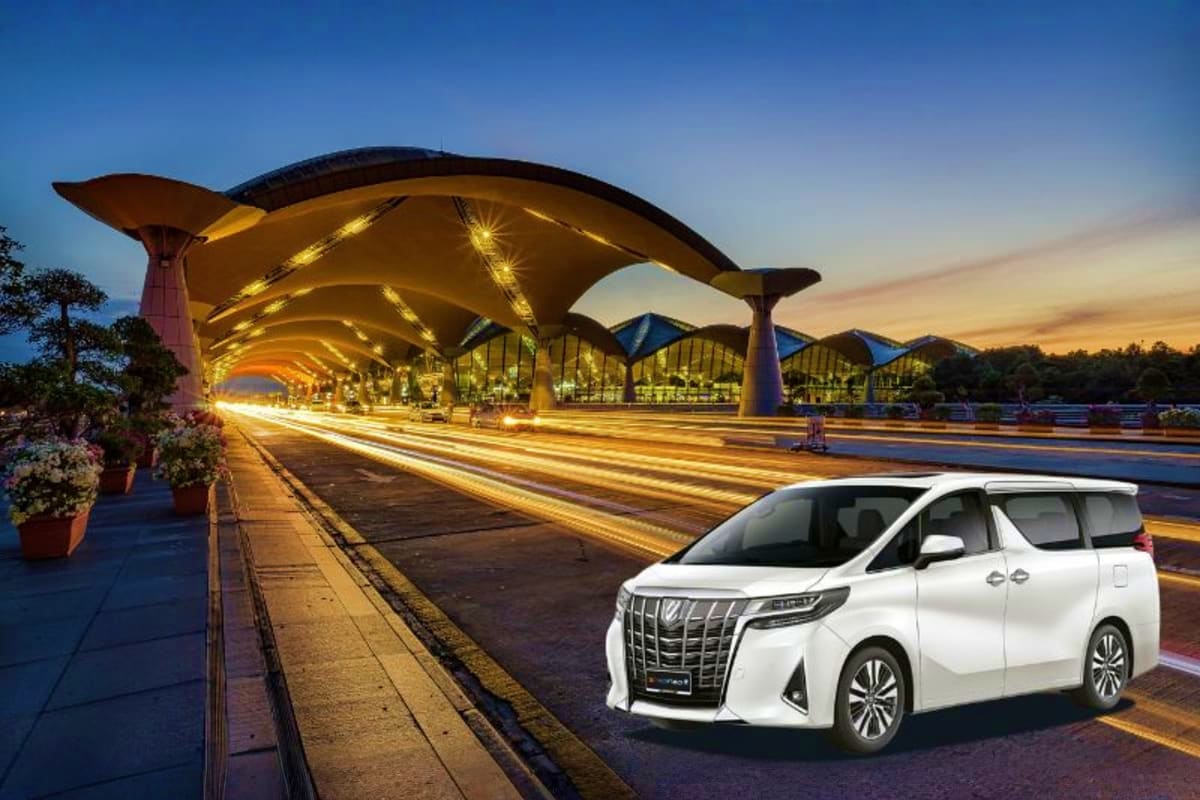 White luxury minivan parked at illuminated modern transit station with curved golden architecture at dusk