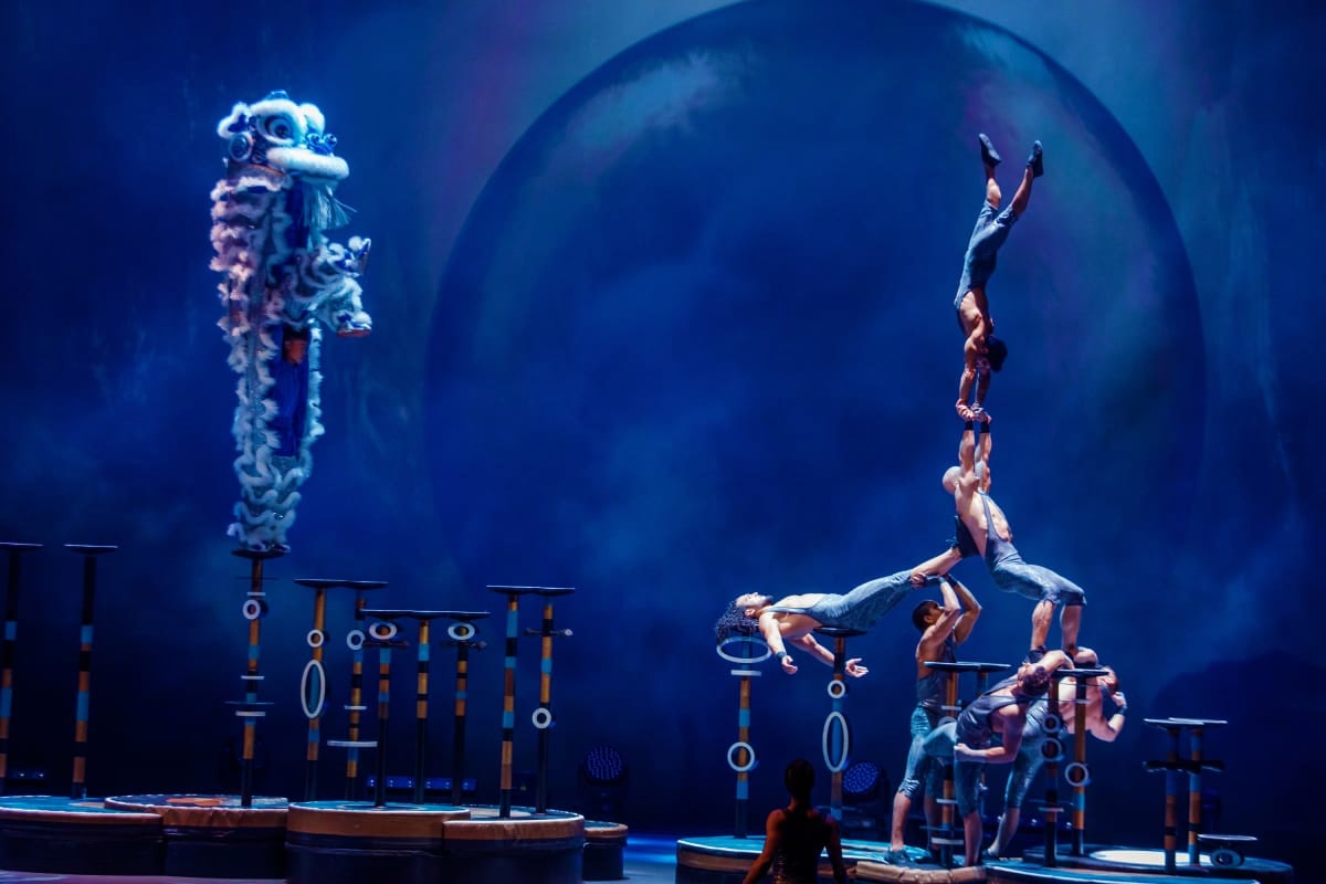 La Perle by Dragone Dubai Acrobatic performers stacked in human pyramid formation performing aerial stunts during La Perle by Dragone Dubai water show