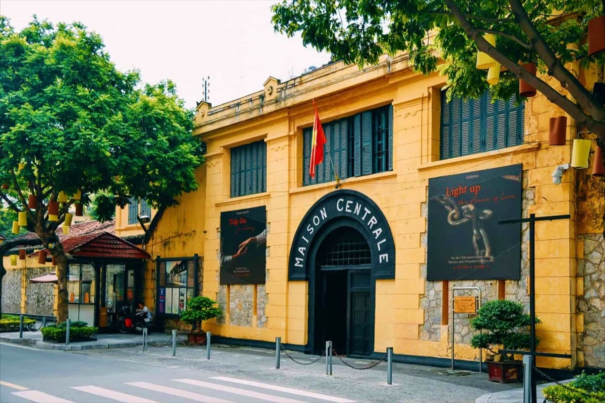 Yellow colonial building with "Maison Centrale" entrance sign, displaying historical exhibitions about Vietnamese military hi
