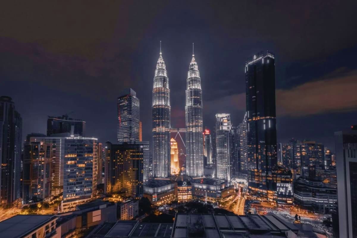 Petronas Twin Towers Kuala Lumpur Illuminated Petronas Twin Towers at night in Kuala Lumpur skyline with surrounding buildings and city lights
