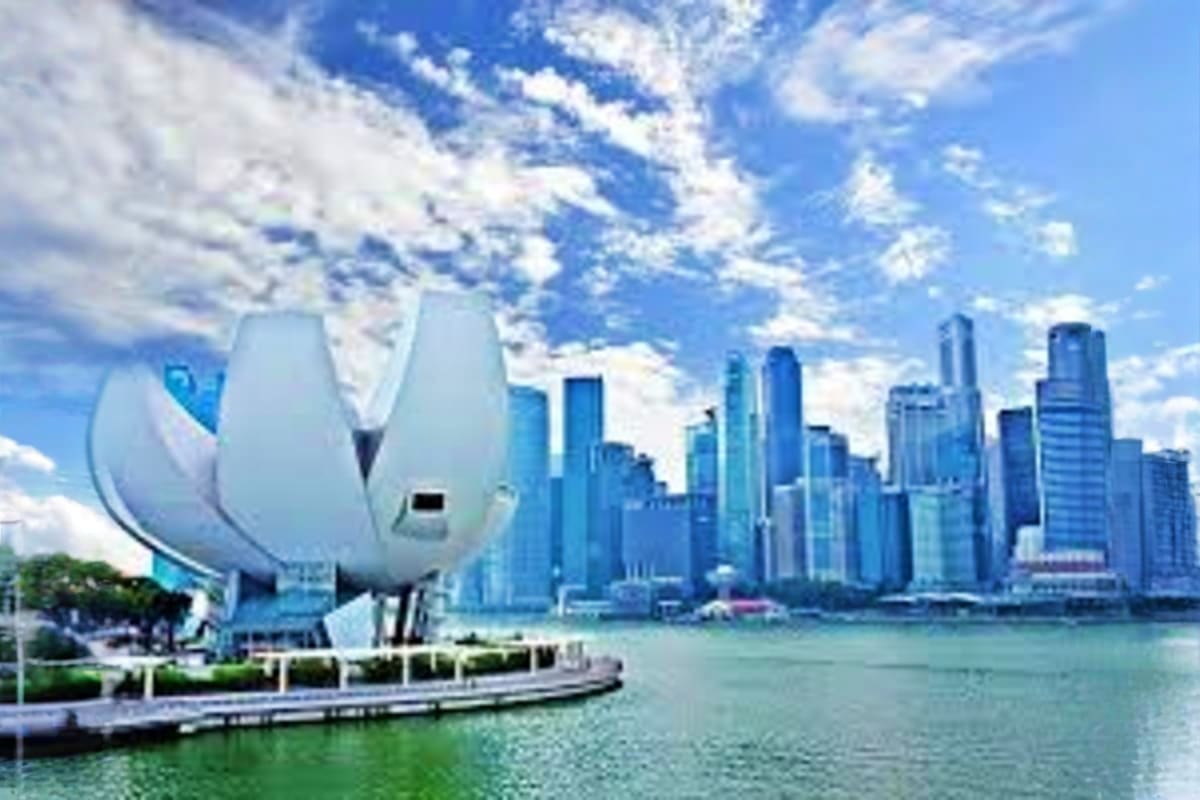 Singapore City Tour With Guide White sculptural sail-shaped building on waterfront with Singapore city skyline and skyscrapers in background across harbor