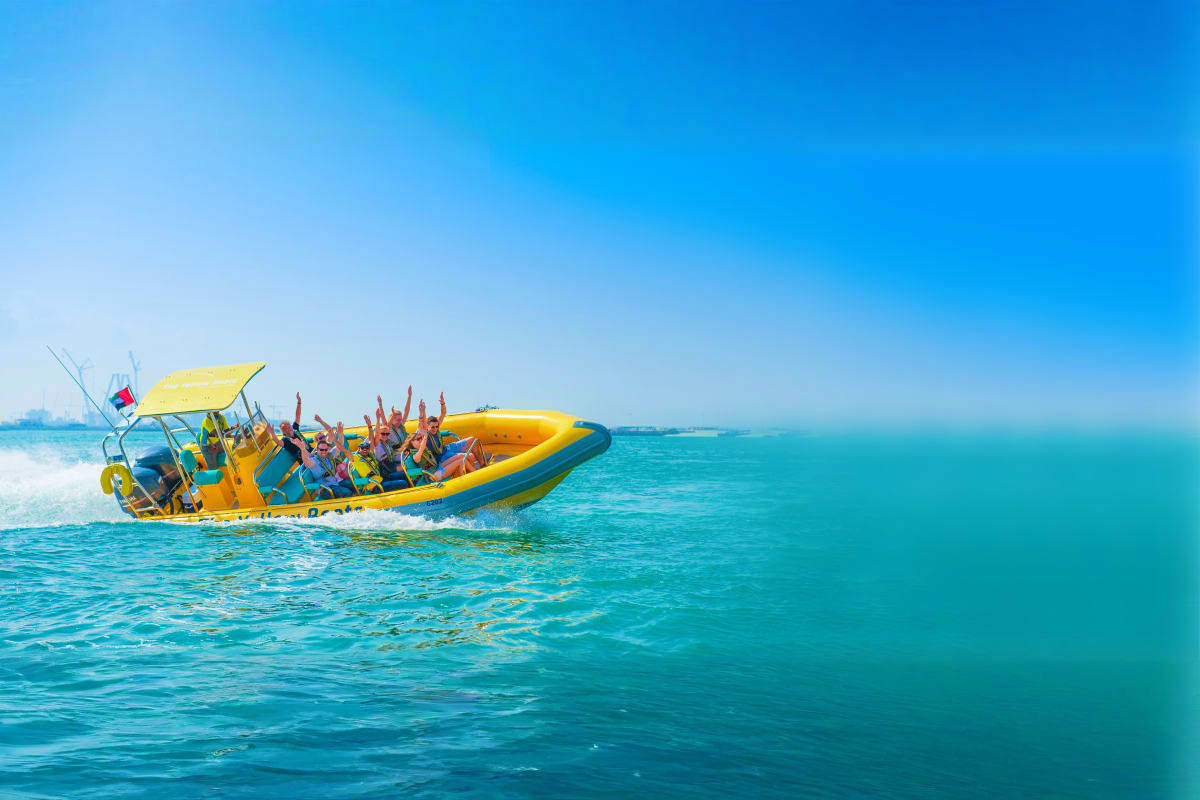 Yellow Boats Dubai Group of tourists with hands raised on yellow speedboat in turquoise Arabian Gulf waters near Dubai