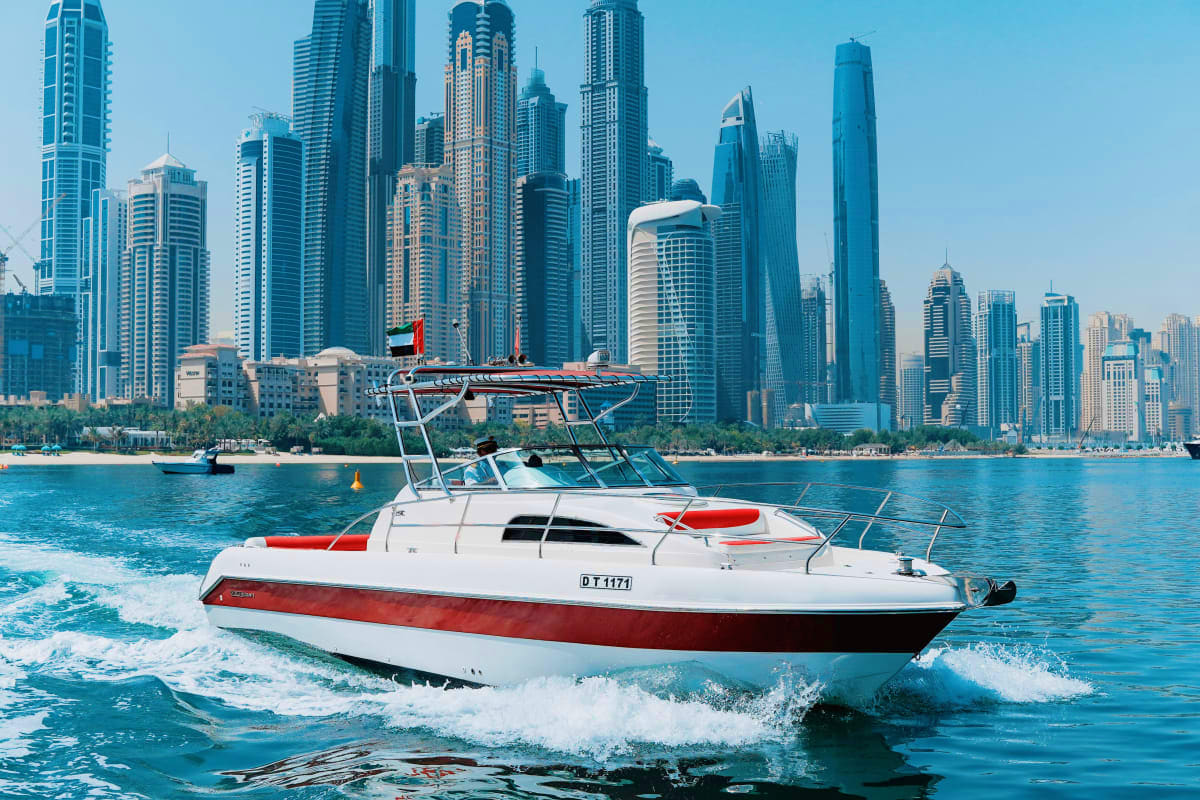 Silver Craft - X5 Red and white speedboat with canopy in turquoise waters with Dubai skyline and high-rise buildings in background