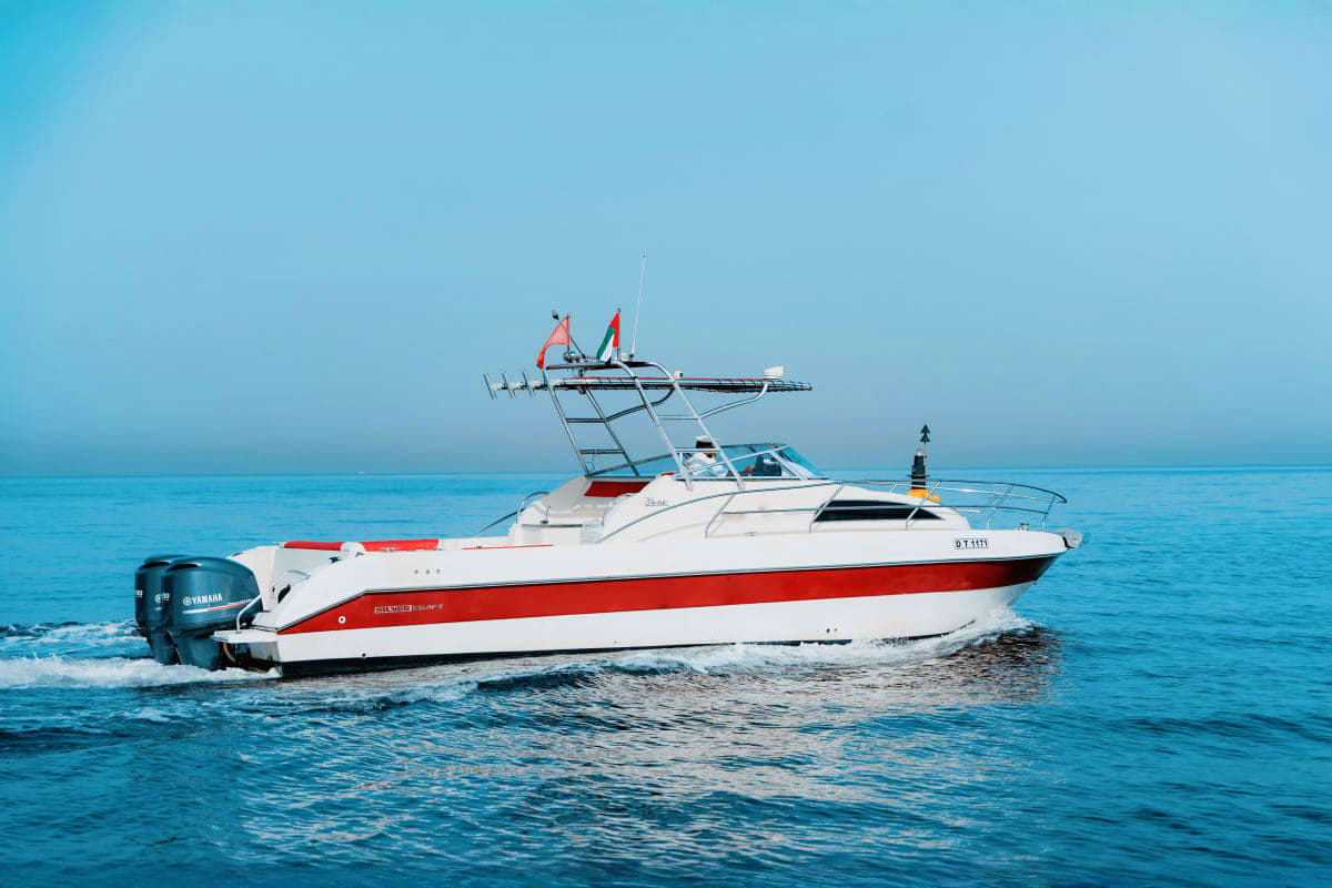 Silver Craft - X5 White and red Silver Craft X5 sport fishing yacht with extended tower moored in clear turquoise ocean waters