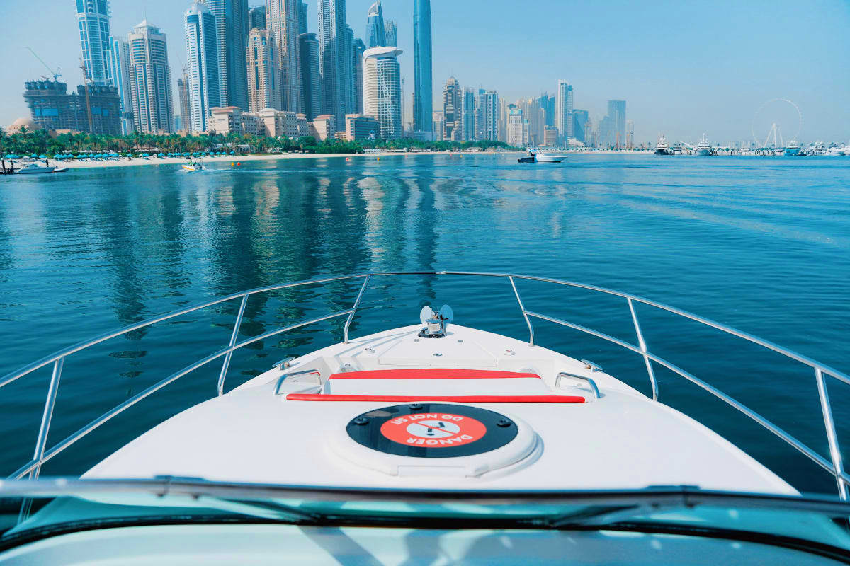 Silver Craft - X5 View from the bow of Silver Craft X5 yacht facing Dubai Marina skyline with turquoise water and moored boats