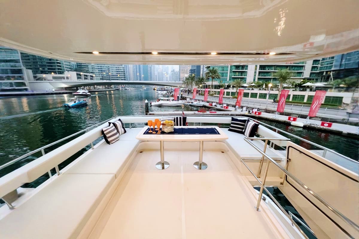 Custom X32 yacht upper deck with striped seating, bar, and water view of Chicago River Marina with boats and city skyline