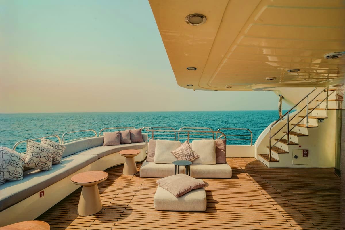 Stardom Luxury yacht Stardom upper deck lounge with curved seating, cushions, and ocean views at horizon