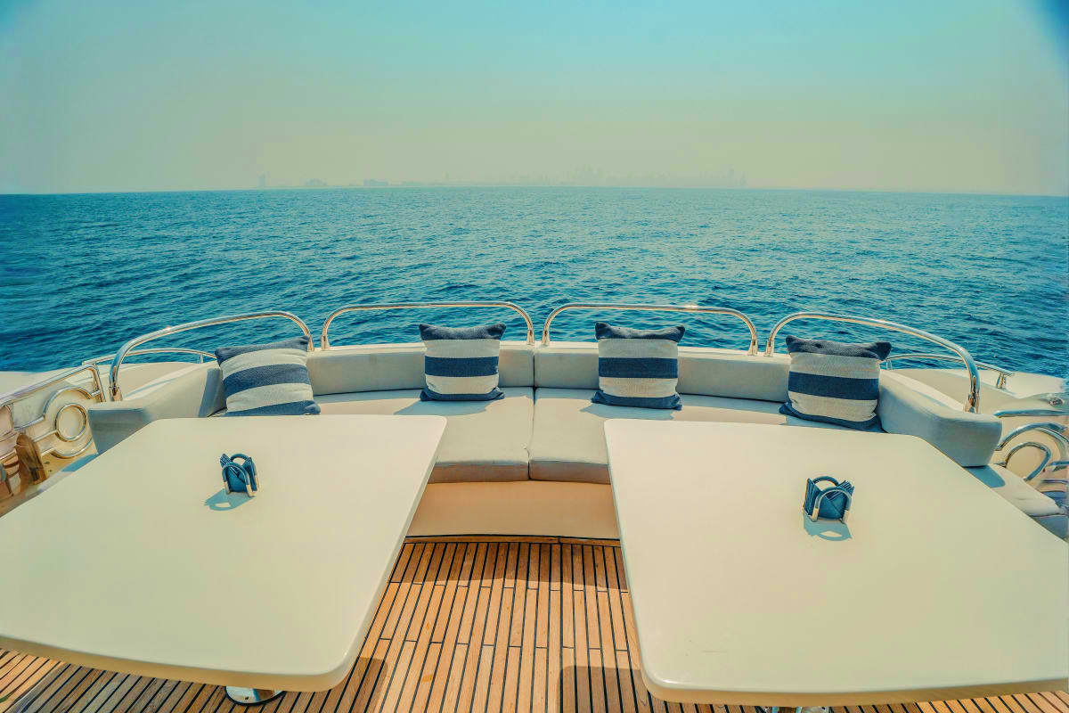 Stardom Luxury yacht Stardom deck with white seating, striped pillows, and calm turquoise ocean horizon