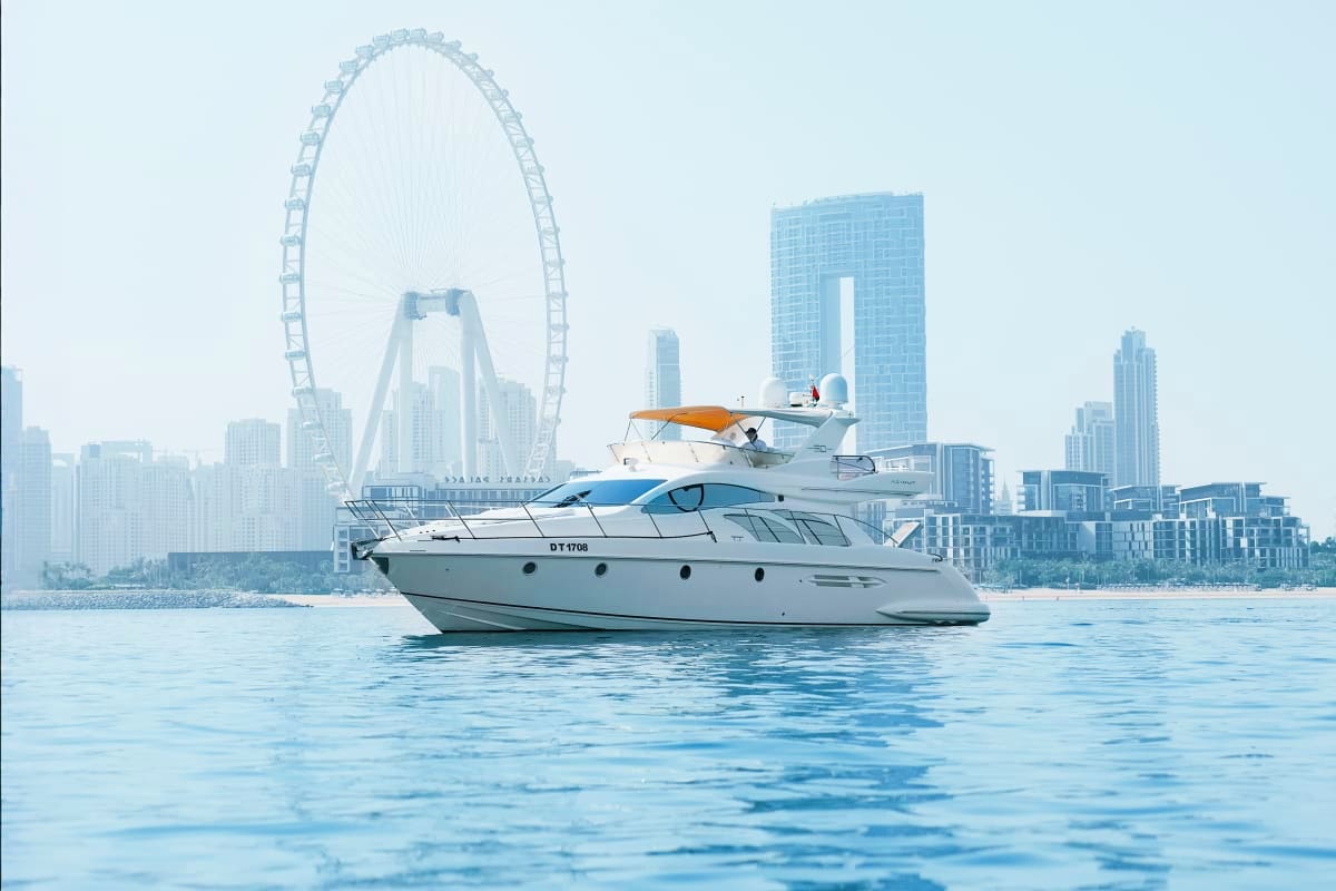 50 Ft Grand Voyage Yacht moored in blue water with London Eye ferris wheel and city skyline in background