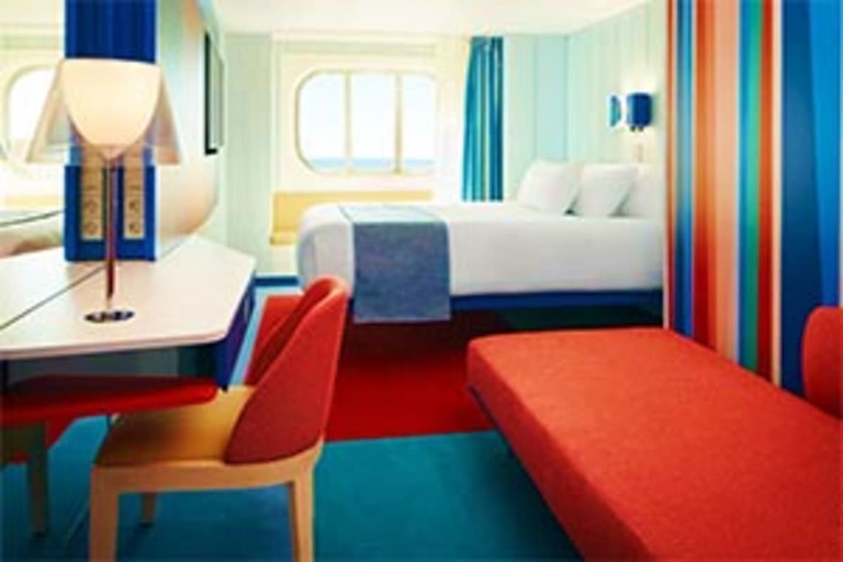 Costa Toscana Western Mediterranean Cruise Modern cruise ship cabin with twin beds, desk with lamp, colorful striped curtains, and ocean view window