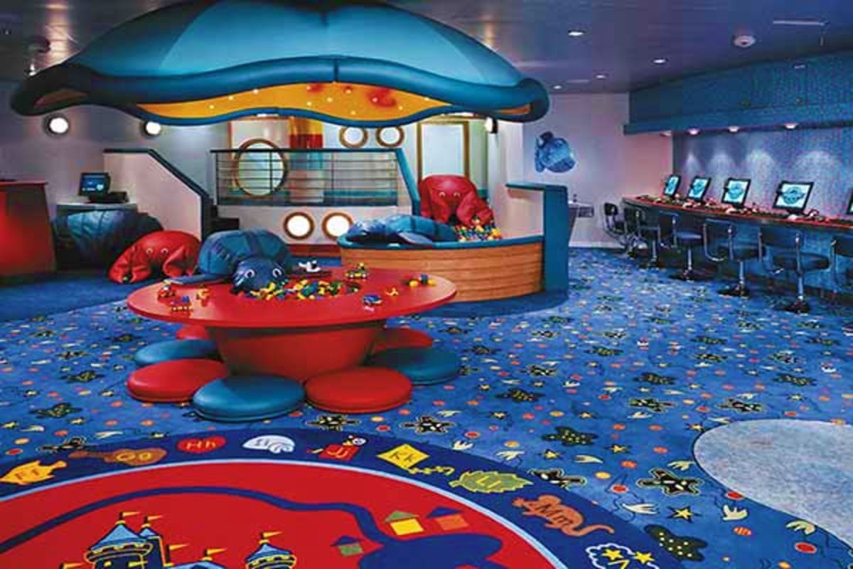 Spectrum of the Seas Japan Cruise Colorful children's play area with UFO-shaped structures, red and blue seating, and space-themed floor design on a cruise shi