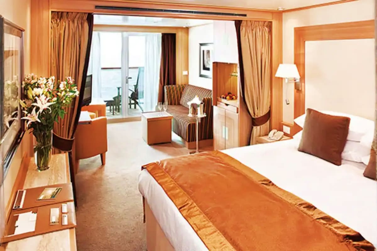 Seabourn Quest Aegean Gems Cruise Luxury cruise ship cabin with twin beds, warm wood furnishings, sitting area, and balcony with ocean view