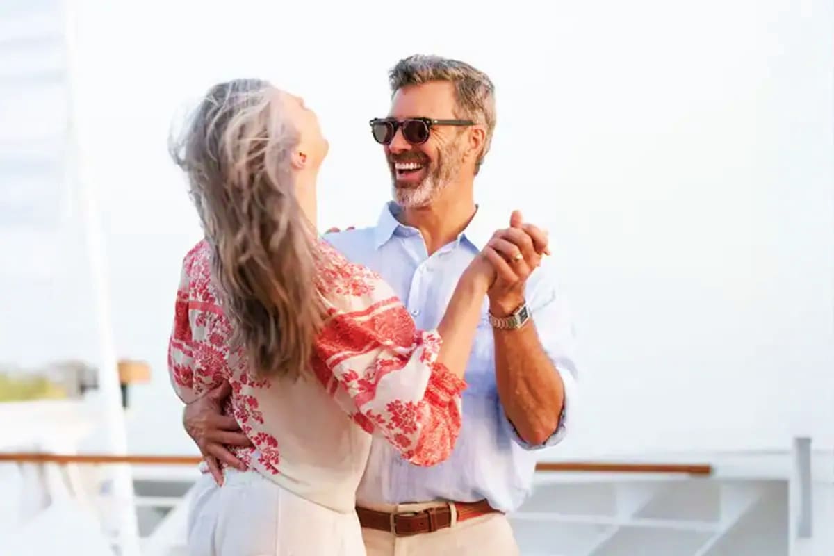 Seabourn Quest Aegean Gems Cruise Middle-aged couple dancing together on a ship deck with ocean and sky in background