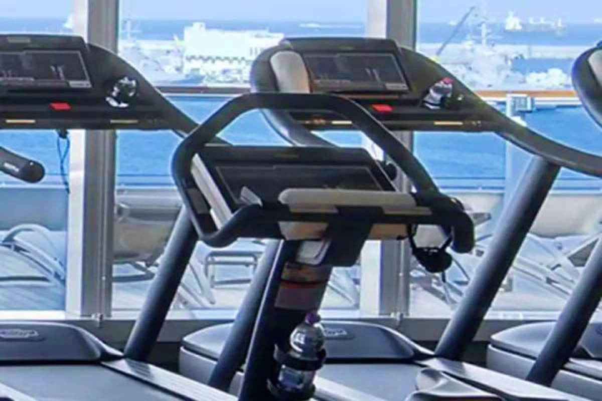 Seabourn Quest Adriatic Greek Treasures Modern cardio exercise equipment with ocean and coastal port views through large windows aboard a cruise ship