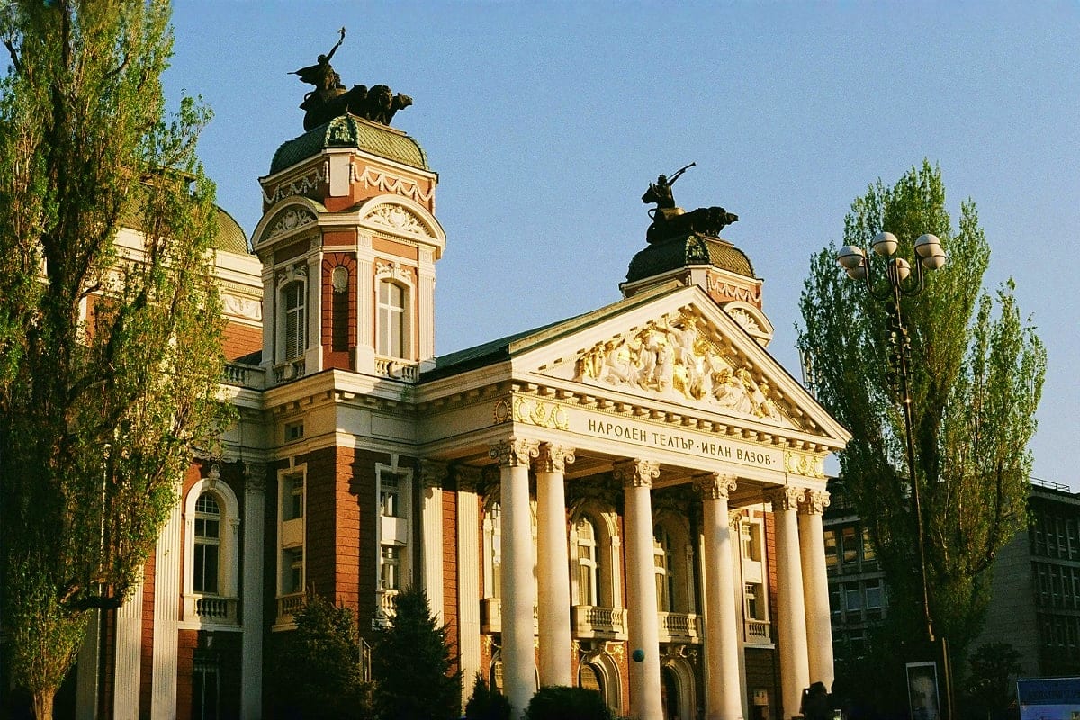 Sofia to Varna Cultural Trail Ivan Vazov National Theatre in Sofia, Bulgaria with classical architecture, white columns, and equestrian statues on domed to