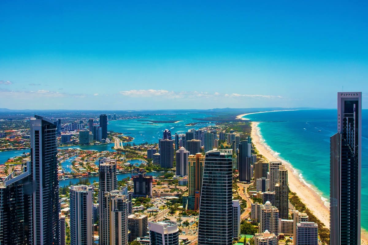 Aerial view of Gold Coast high-rise buildings and golden sandy beach with turquoise ocean waters in Australia