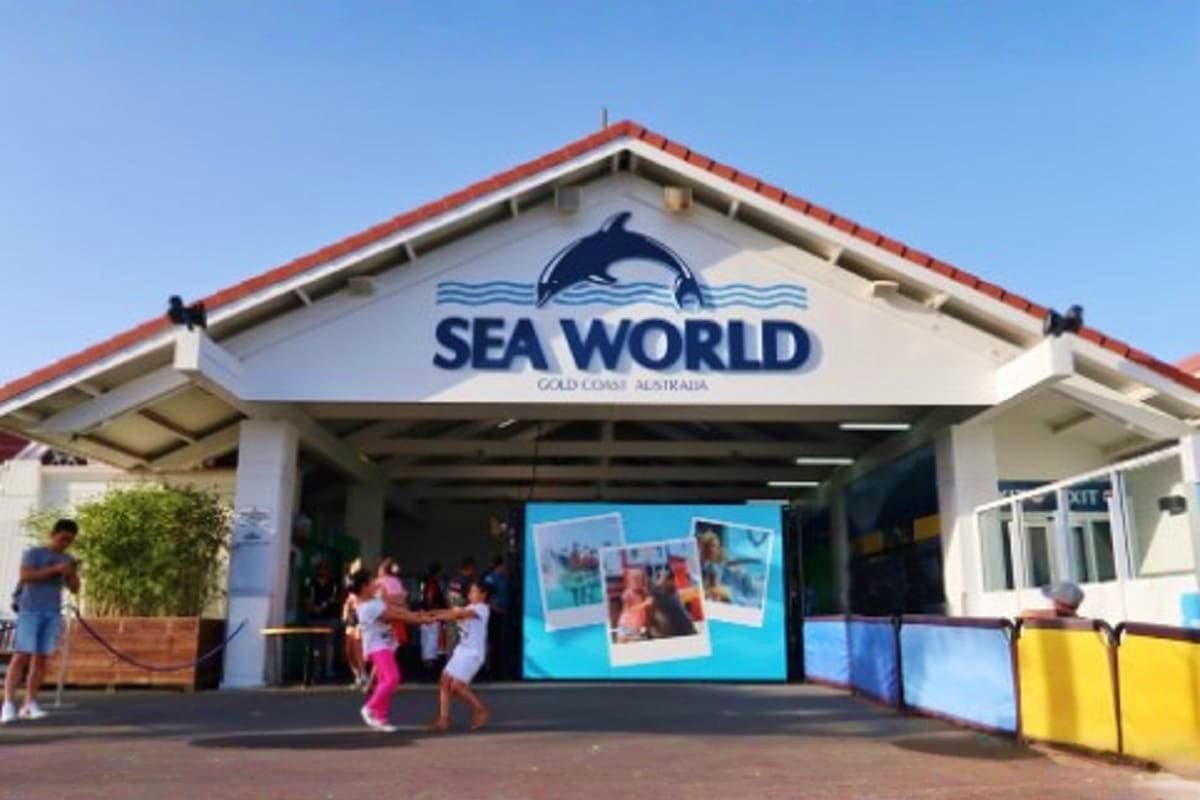 Sea World Gold Coast Australia entrance with dolphin logo, visitors at gate on sunny day