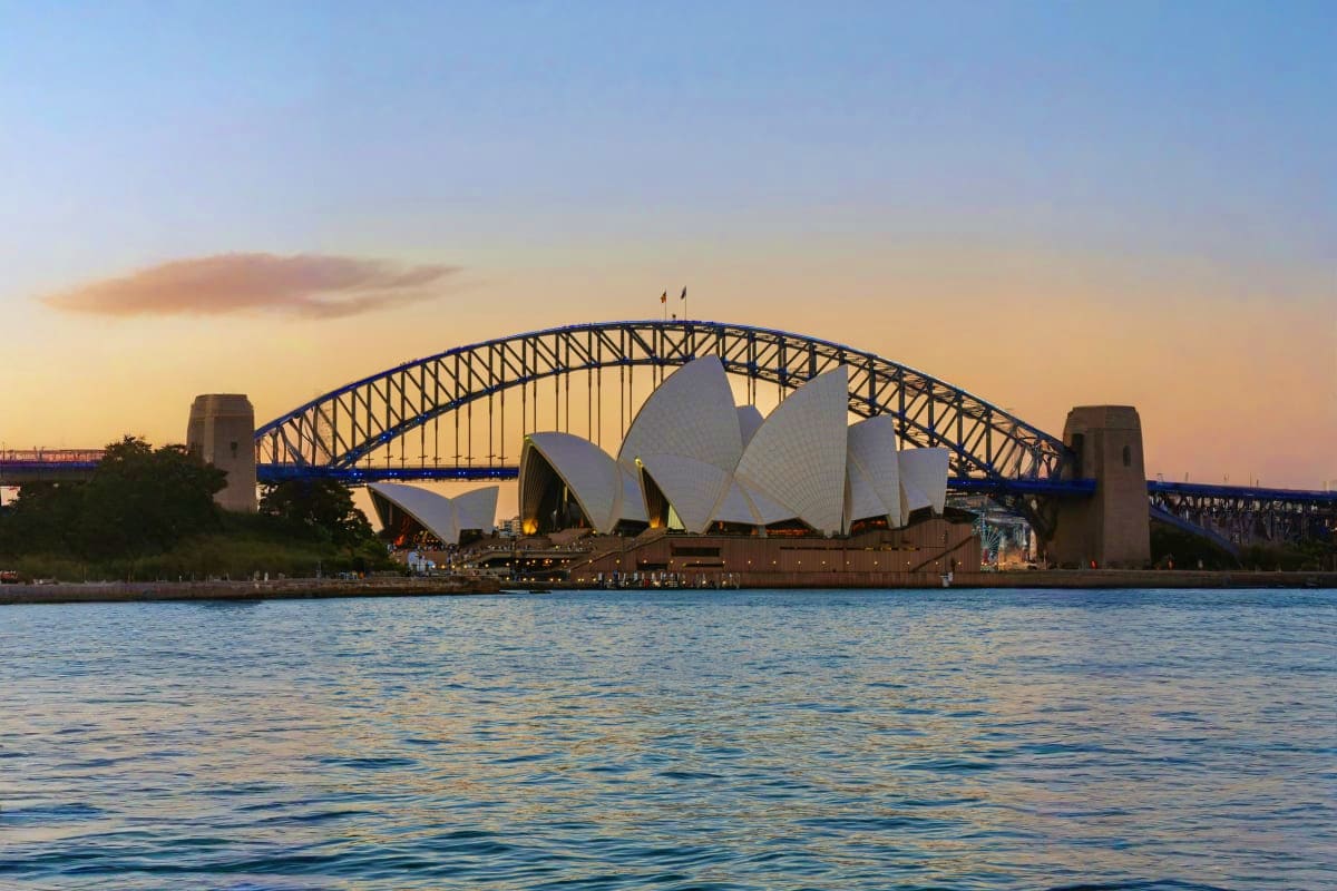 Sydney Opera House and Harbour Bridge at sunset viewed from across the water, Sydney Australia