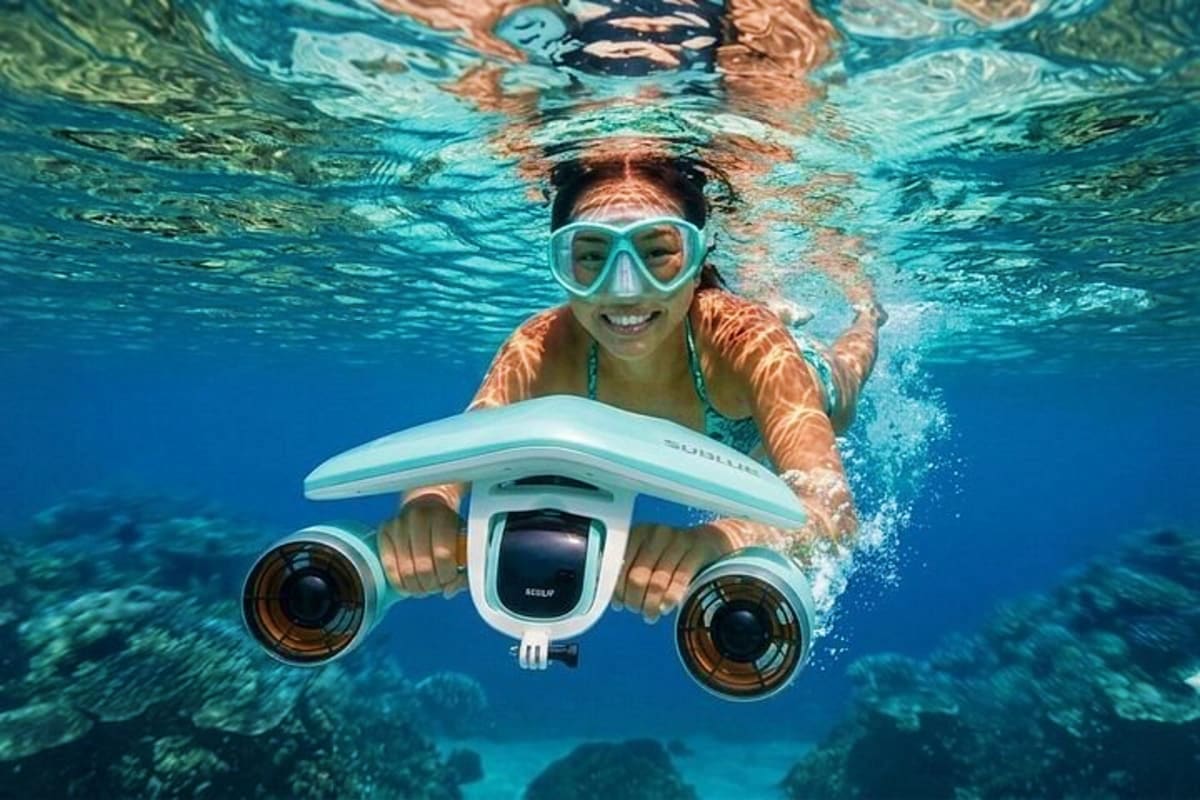 Simply Siargao Woman snorkeling underwater holding a white underwater drone with cameras in clear blue ocean water