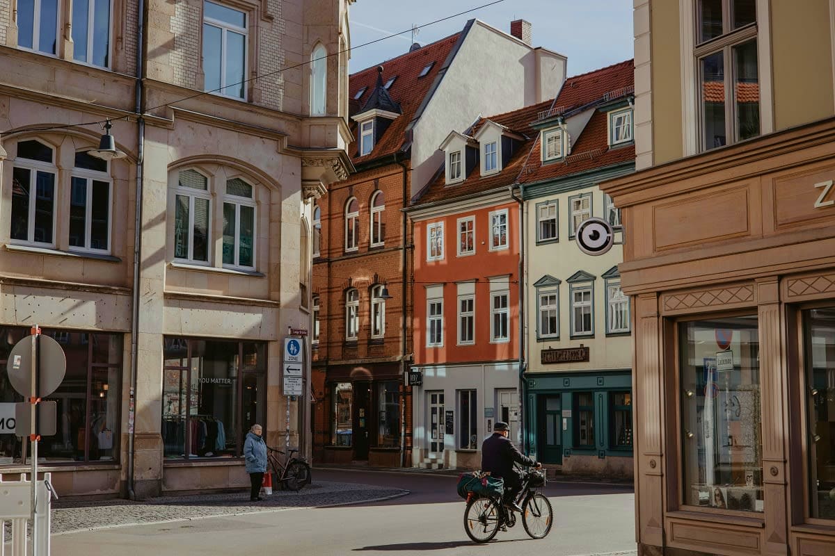 European town square with colorful historic buildings and a cyclist riding through the pedestrian street