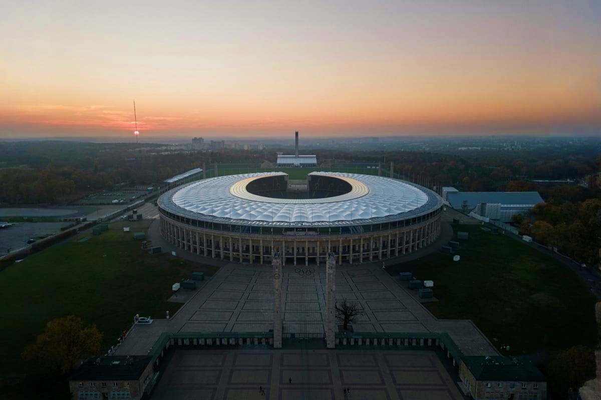 Olympiastadion Berlin aerial view at sunset with circular stadium roof and surrounding landscape