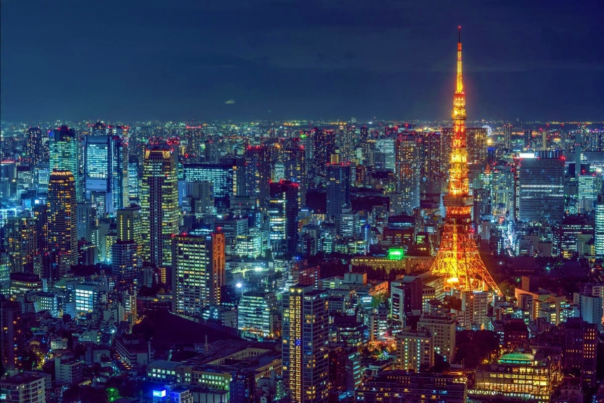 Tokyo skyline at night with illuminated Tokyo Tower and surrounding skyscrapers lit up in the evening cityscape