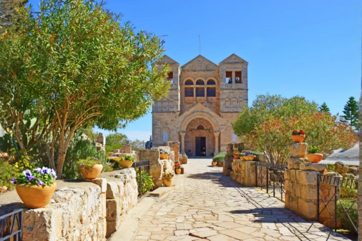 Romantic Czech Republic Tour Package – Bohemia and Moravia Church of the Multiplication of the Loaves and Fishes in Tabgha with stone pathway, terracotta potted flowers, and Mediterran