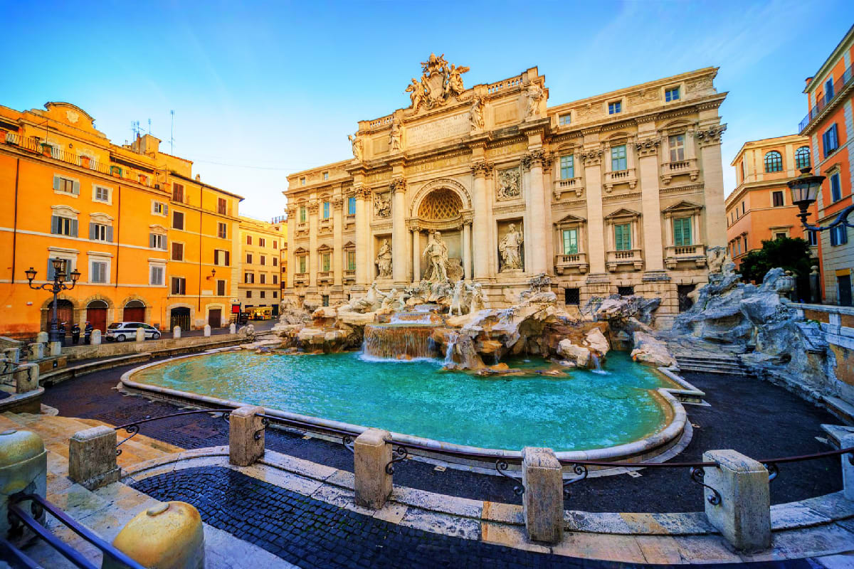 Trevi Fountain in Rome with turquoise water, baroque architecture, and golden-hued buildings surrounding the famous Italian l