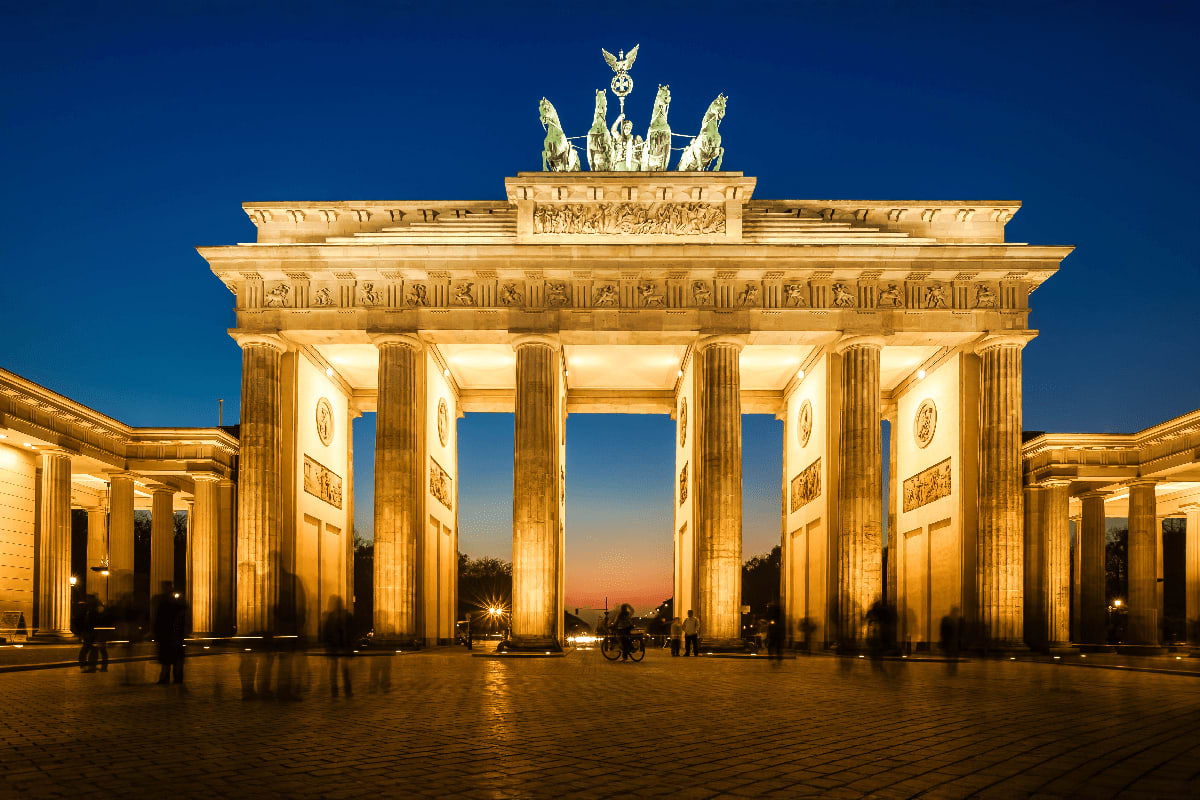 Brandenburg Gate illuminated at dusk in Berlin, Germany, with neoclassical columns and quadriga sculpture on top