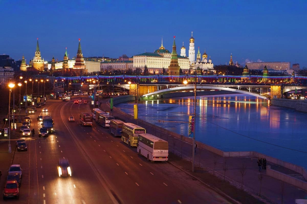 Moscow Kremlin and Moscow River at twilight with illuminated towers, bridges, and historic architecture reflected in blue wat