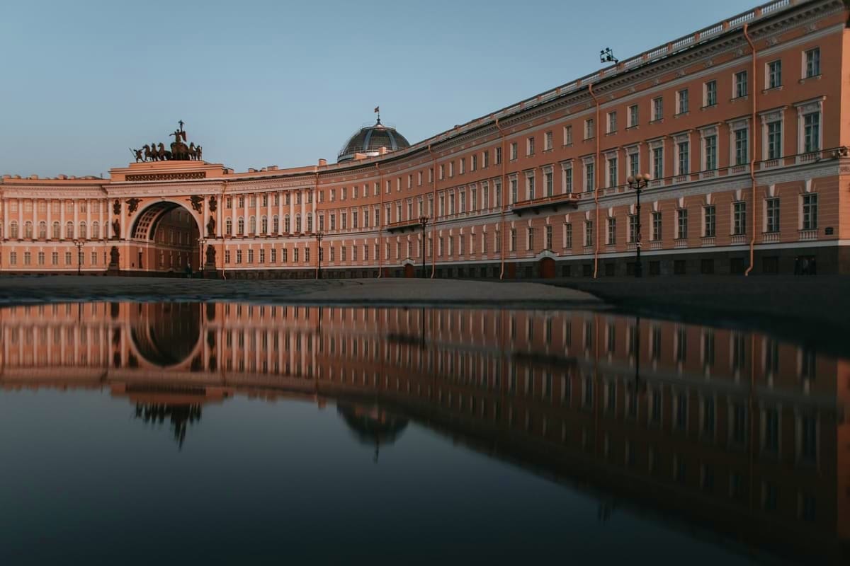 Winter Palace in Palace Square, St. Petersburg, reflected in frozen water with neoclassical architecture and dome