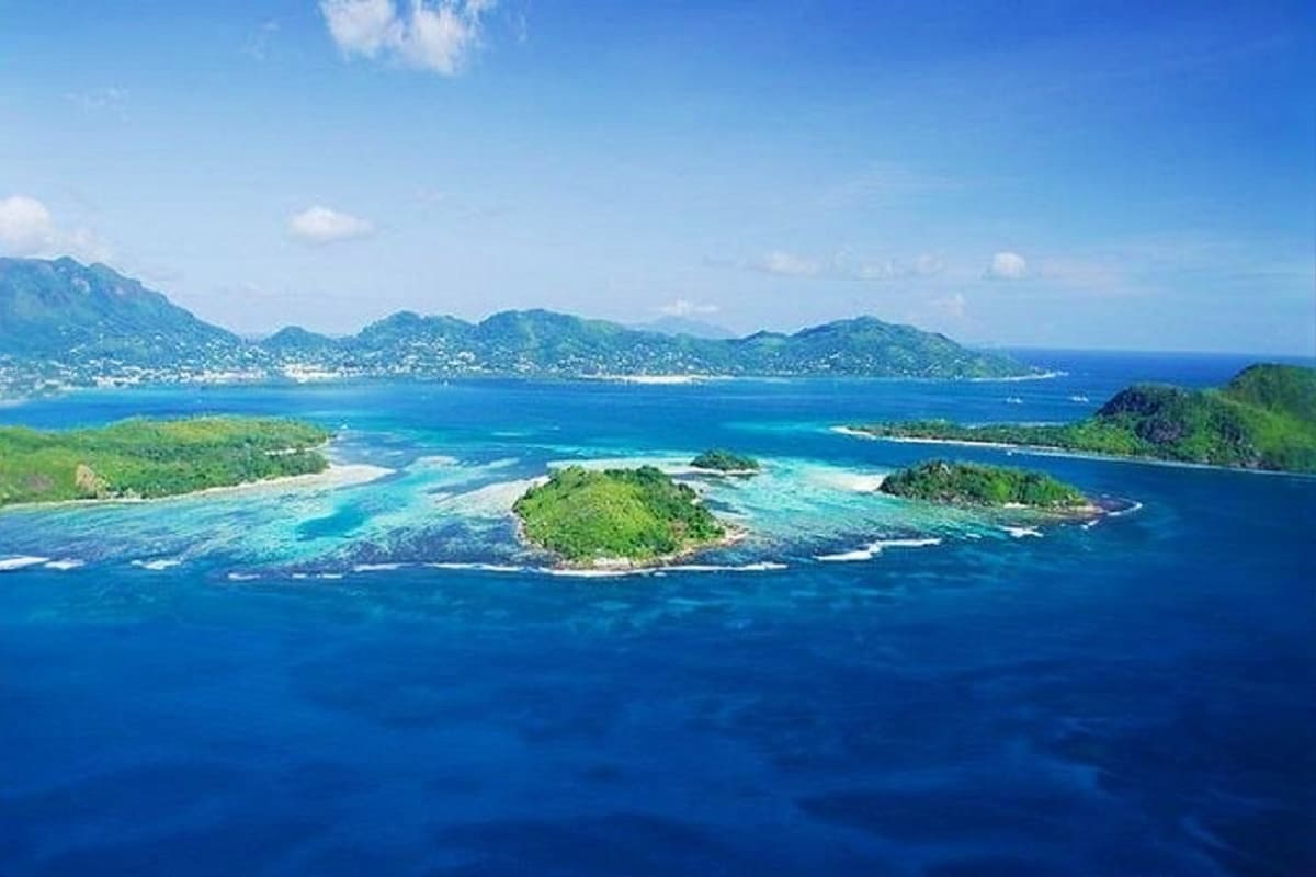 Aerial view of lush tropical islands surrounded by turquoise waters and coral reefs in the Seychelles archipelago