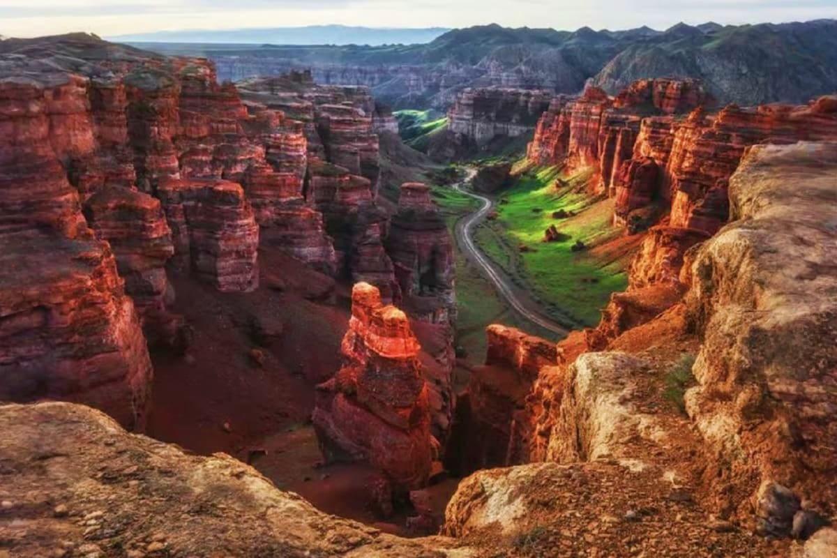 Red sandstone canyons with winding river valley and green meadows, Charyn Canyon landscape in Kazakhstan