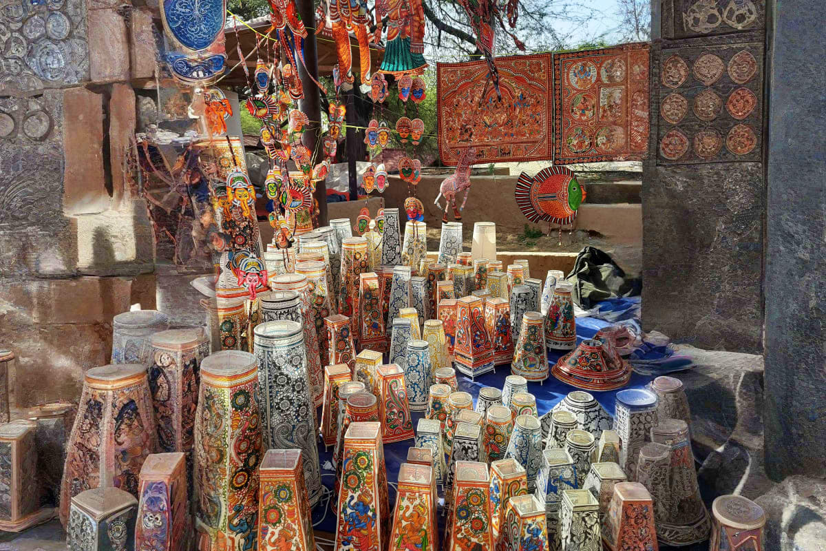 Traditional Armenian pottery and decorative items displayed at an outdoor market stall with ornate tiles and crafts