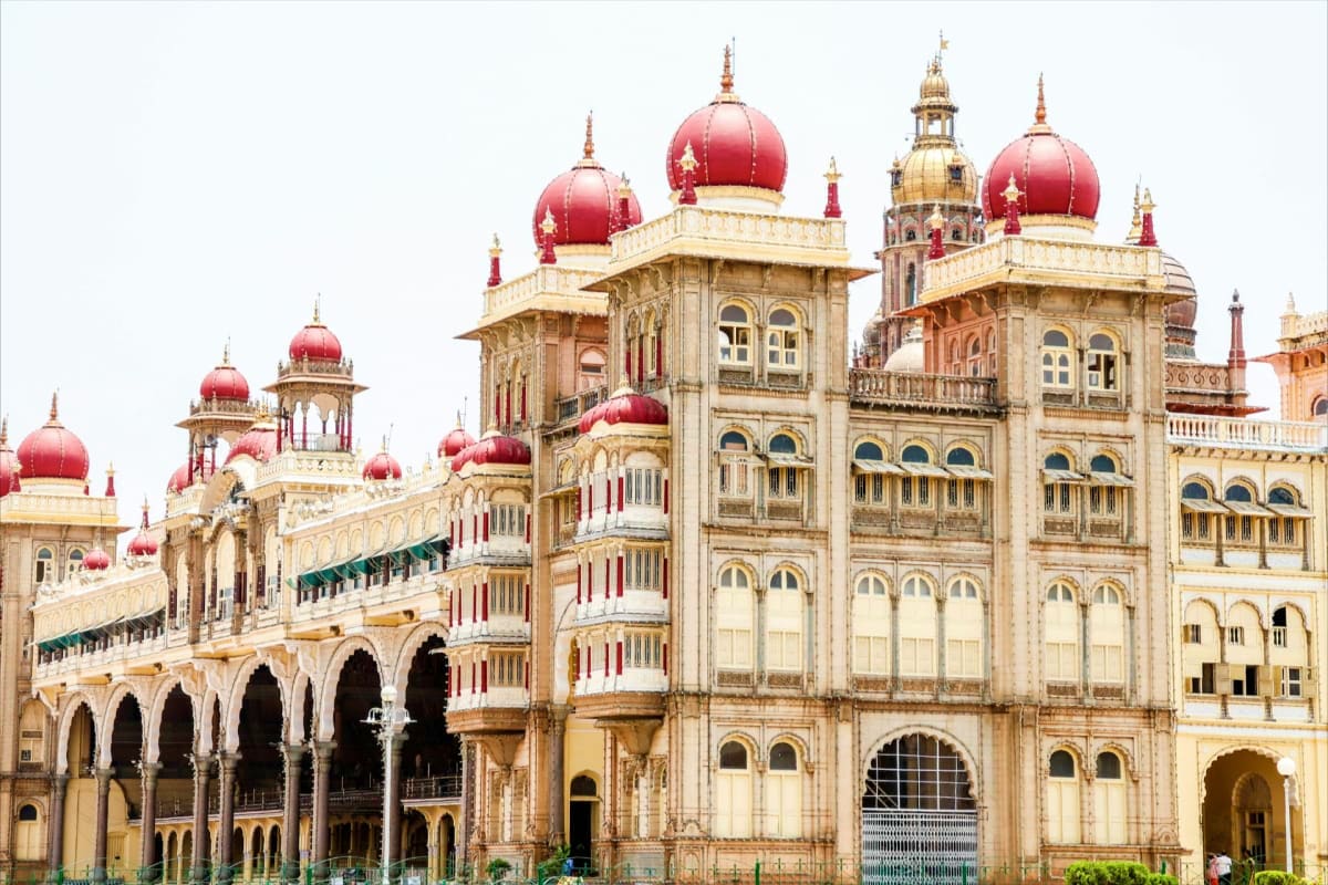 Mysore Coorg Ooty Scenic Family Tour Historic palace with red domes and cream-colored architecture featuring ornate arches and detailed facades in Mysore, India