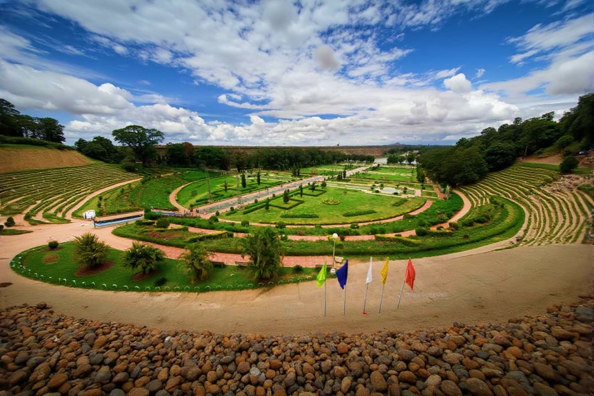 Mysore Coorg Ooty Scenic Family Tour Aerial view of spiral garden landscape with manicured green lawns, walking paths, and colorful flags at a scenic tourist dest