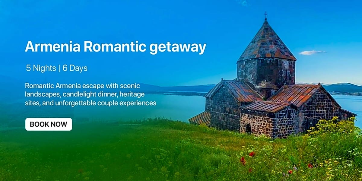 Ancient stone church with conical roof on grassy hillside overlooking blue lake and mountains under clear sky