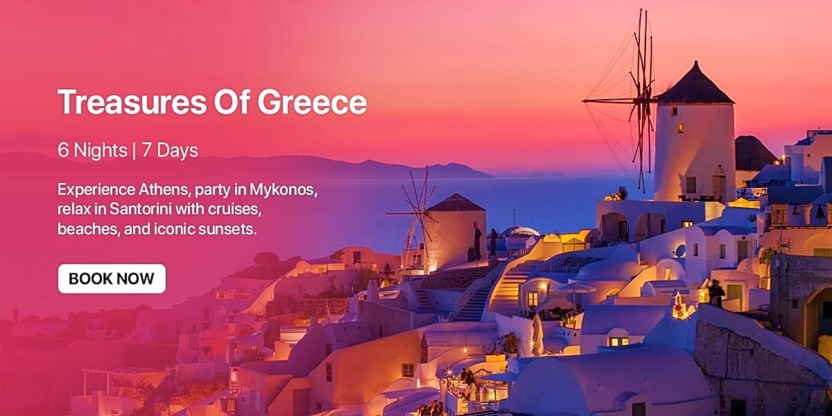Sunset view of Santorini's white-washed buildings and iconic windmills overlooking the Aegean Sea at dusk