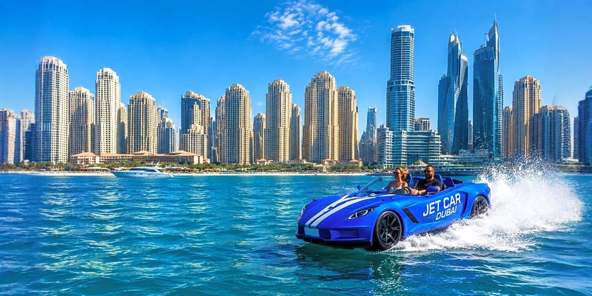 Blue jet car speeding through Dubai marina water with modern skyscraper skyline in background under clear sky
