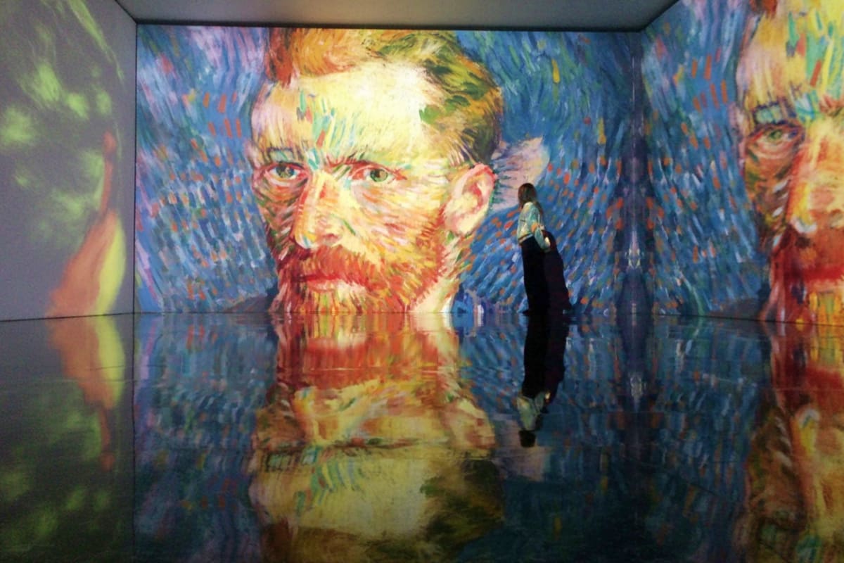 Art In Island The Media Square Person viewing large projected portrait of Van Gogh self-portrait in immersive art installation at Art In Island The Media Sq