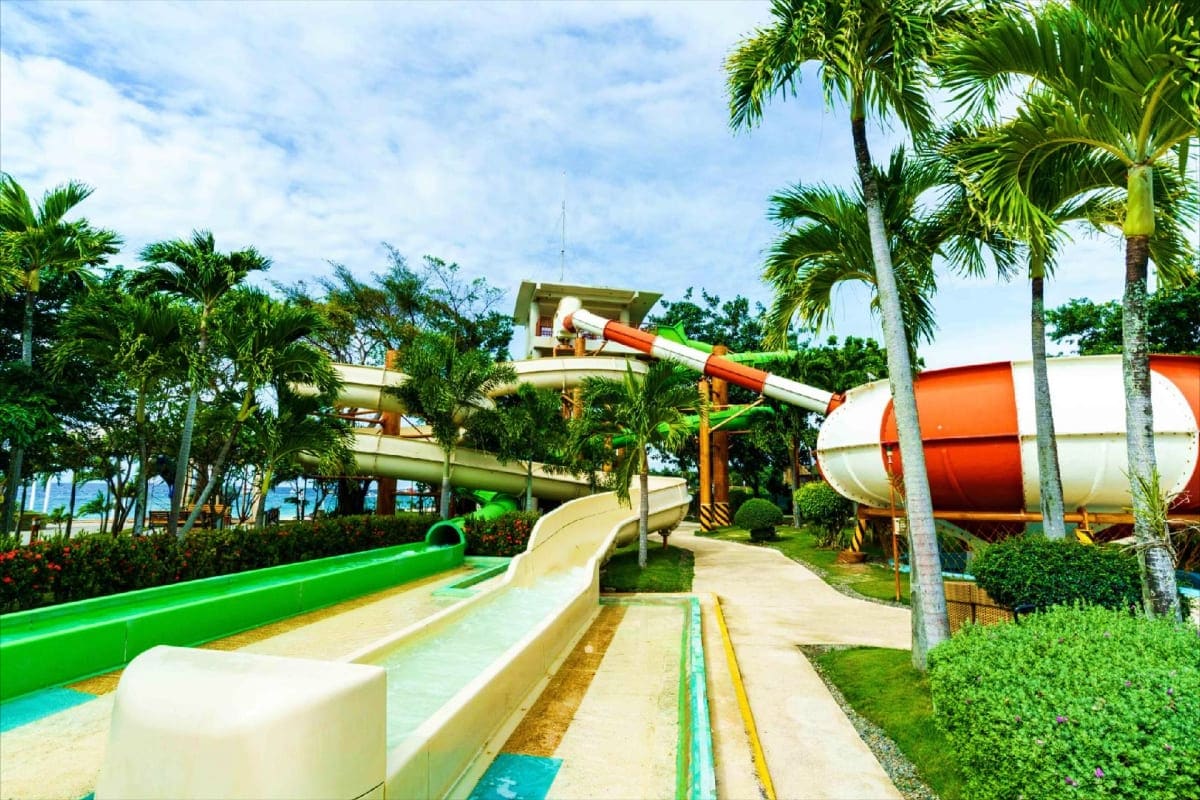 Water park at Jpark Island Resort with colorful slides, palm trees, and tropical landscaping