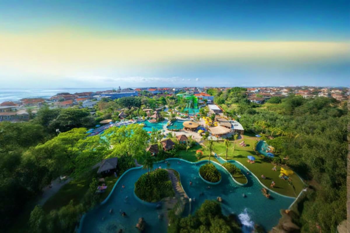 Waterbom Bali Aerial view of Waterbom Bali water park with blue pools, water slides, green landscaping, and coastal town in the background