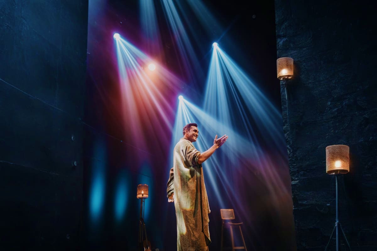 Khushiyan Live Storytelling Experience with Laksh Maheshwari In Dubai Actor performing on stage under dramatic blue and purple spotlights during live storytelling performance in Dubai theater