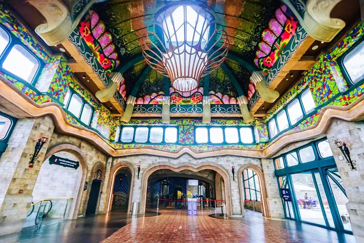 Interior of ornate Asian-style pavilion with colorful decorative ceiling, symmetrical arched doorways, and natural light from
