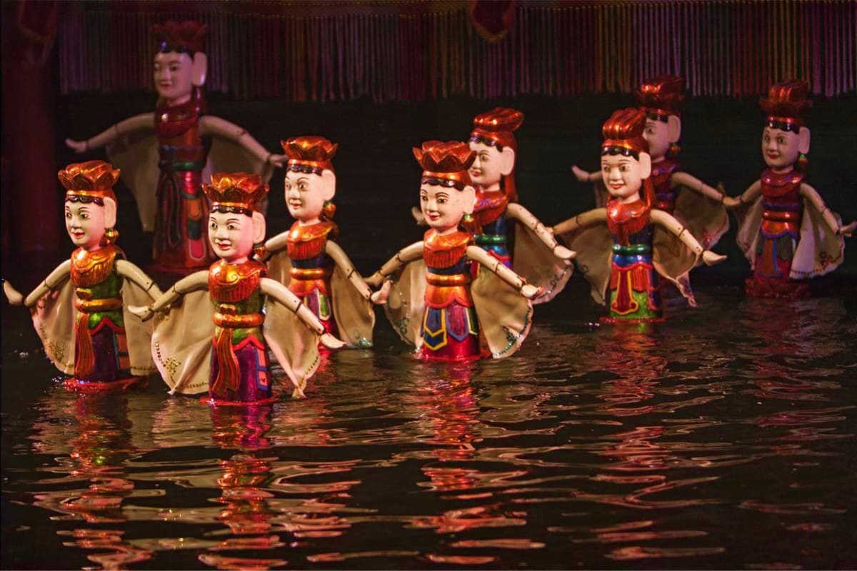 Water Puppetry Show and Dinner On Cruise Water puppets in traditional Vietnamese costumes performing on water stage during puppet theater show