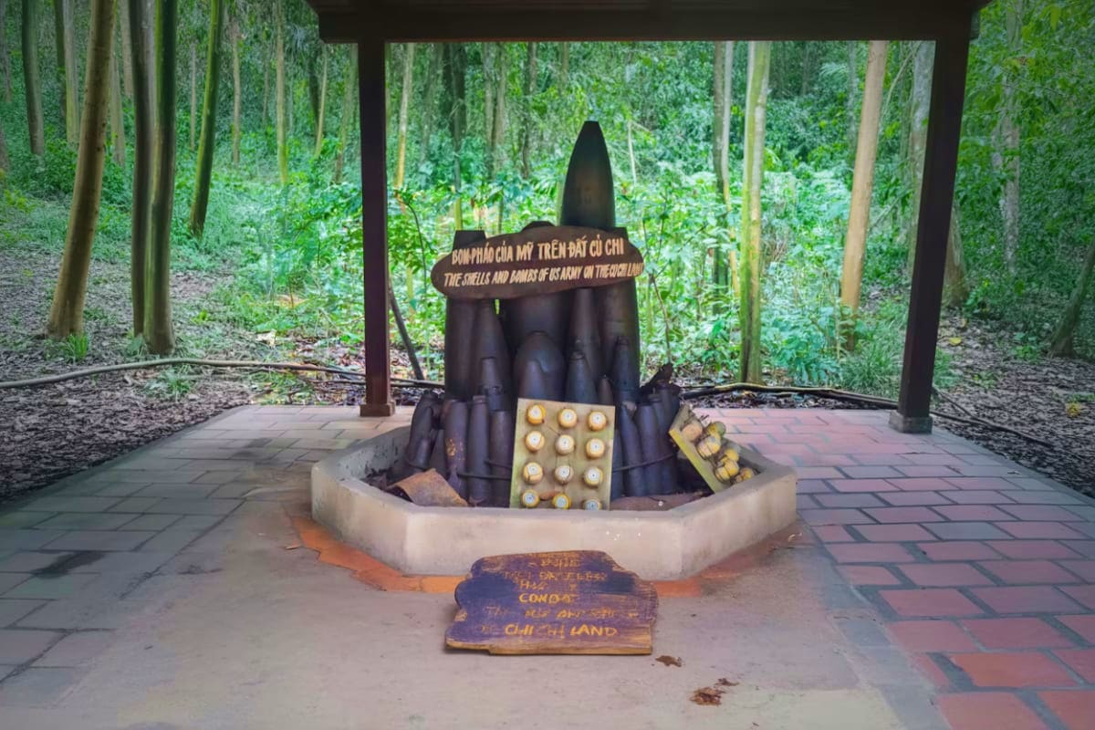 Cu Chi Tunnel Private Transfer War memorial monument displaying large bomb replica and candles at Cu Chi Tunnels historical site in Vietnam forest