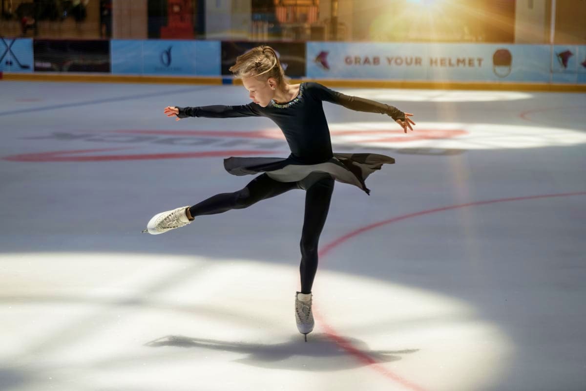 Dubai Ice Rink Young figure skater performing a spinning move on ice at Dubai Ice Rink indoor skating facility