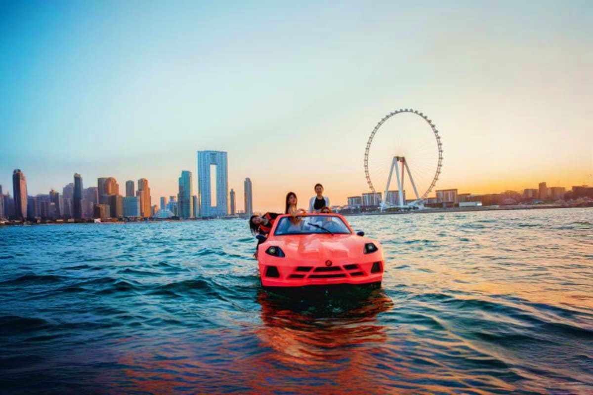 Jet Car Activities Dubai Red sports car floating in water with Dubai skyline and Ferris wheel at sunset