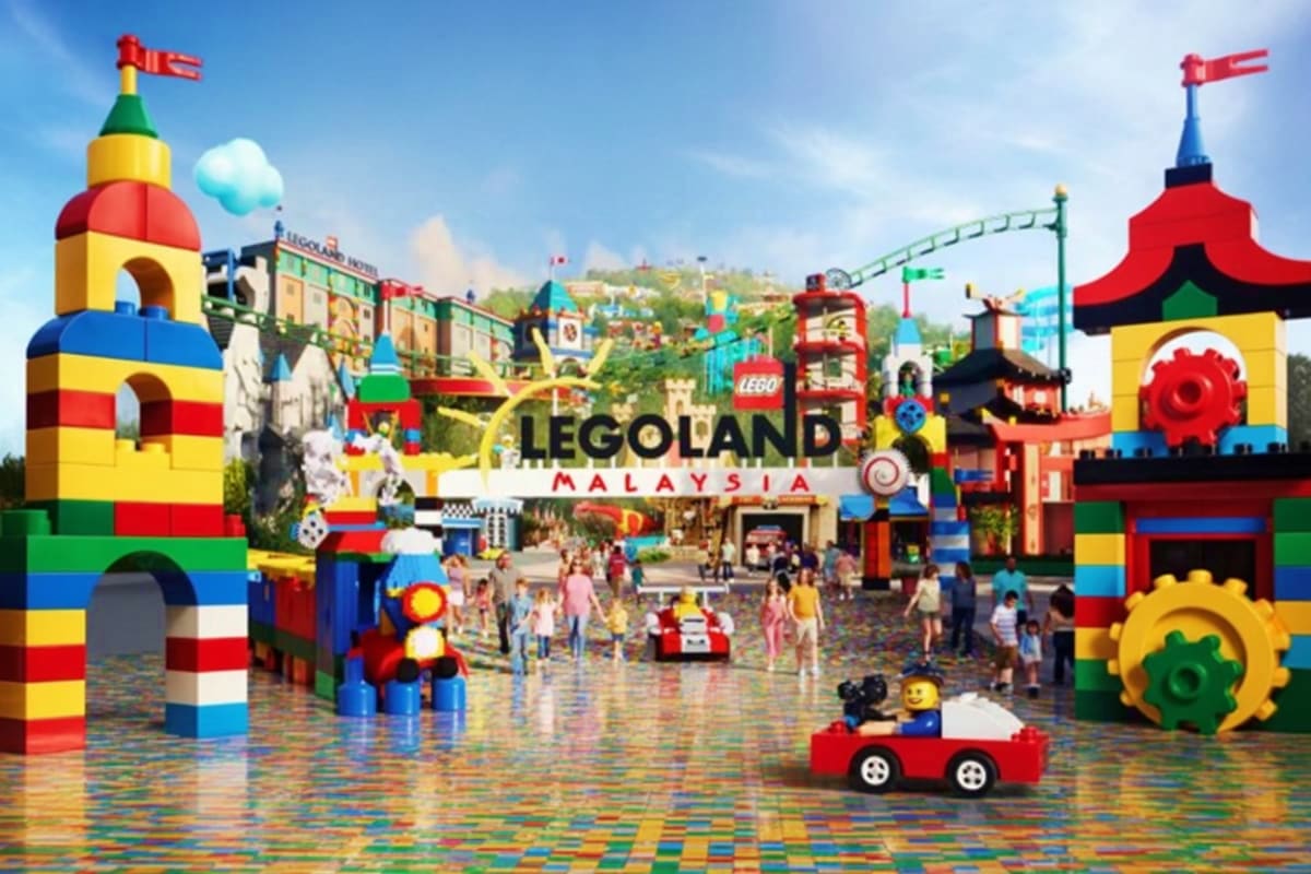 Legoland Malaysia theme park entrance with colorful LEGO brick structures, towers, rides, and visitors enjoying the attractio