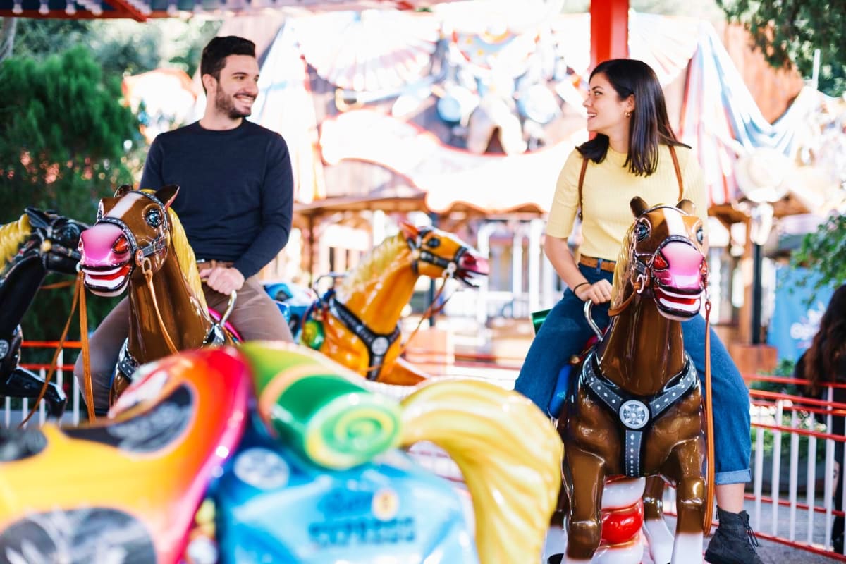 Couple enjoying carousel ride with decorative horses at Legoland Malaysia theme park